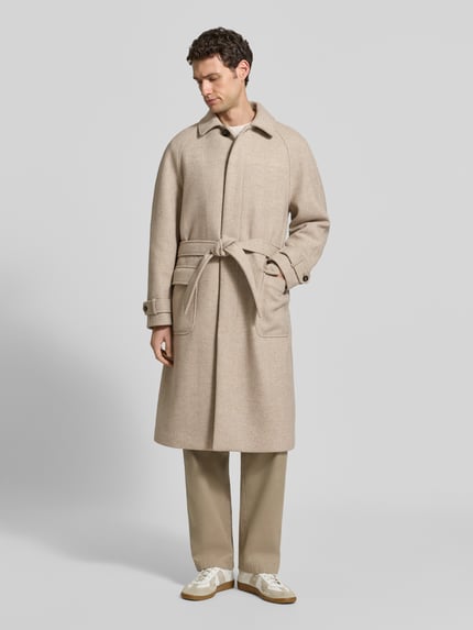 Männermodel trägt Mantel aus Woll-Mix mit Bindegürtel von MCNEAL in Beige, Regular Fit, Pattentaschen, Umlegekragen, Ganzkörperansicht von vorne.
