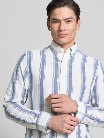 Männermodel trägt Regular Fit Freizeithemd aus Leinen-Baumwoll-Mix mit Kentkragen von Gant, Streifenmuster, Nahaufnahme Oberkörper.