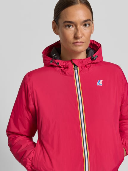 Frauenmodel trägt Regular Fit Jacke mit Logo-Print Modell 'CLAUDETTE' von K-WAY in Pink, Kapuze mit Tunnelzug, Nahaufnahme Oberkörper.