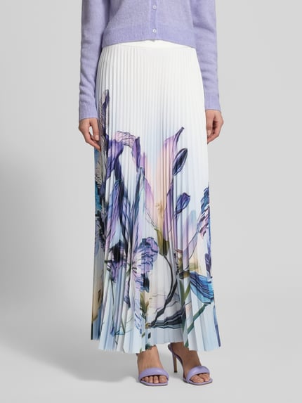 Vrouwenmodel draagt plissérok met labeldetail en zijritssluiting van Marc Cain, dames A-lijn maxirok met onderrok, bloemenprint, totale lengte maat 36: 100 cm, vooraanzicht close-up.