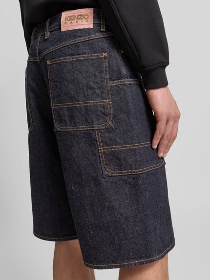 Männermodel trägt Straight Fit Shorts in denimlook van Kenzo, puur katoen, cargozakken, knoop- en ritssluiting, bandwijdte 28 cm, binnenbeenlengte 46 cm, ganzkörperansicht rückansicht.