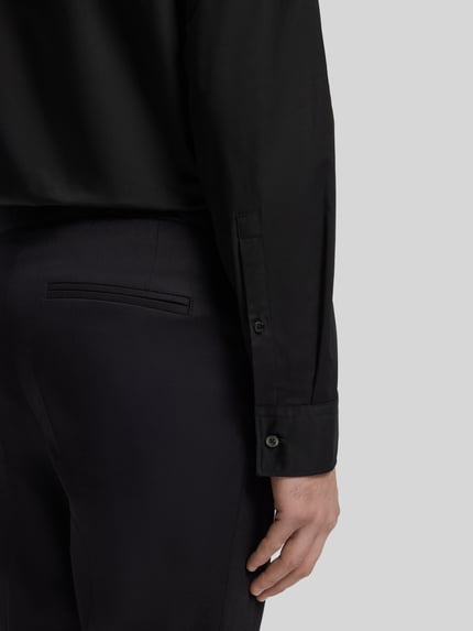 Mężczyzna nosi Slim Fit Freizeithemd aus Baumwoll-Mix Modell 'ERMO' od HUGO, czarny kolor, długi rękaw, detal rękawa, detailaufnahme ręki.