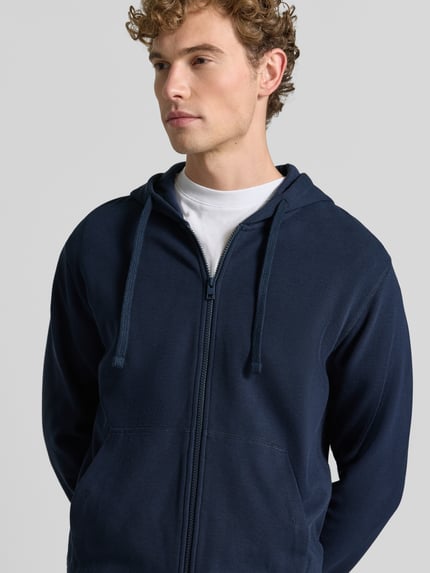 Männermodel trägt Relaxed Fit Sweatjacke aus reiner Baumwolle von s.Oliver RED LABEL in Dunkelblau, Nahaufnahme Oberkörper.
