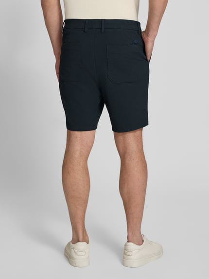 Männermodel trägt Regular Fit Bermudas mit Viskose-Anteil Modell 'KANE1' von BOSS in Melange-Optik, Rückansicht Ganzkörperansicht.