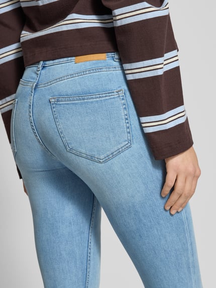 Frauenmodel trägt Flared Fit Jeans im 5-Pocket-Design von Review aus elastischem Baumwoll-Mix in hellem Blau, Detailaufnahme Rückansicht.