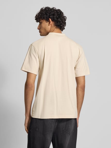 Männermodel trägt Regular Fit Poloshirt aus reiner katoen Modell 'Core' van G-Star Raw in beige met labeldetail, ruglengte maat M 72 cm, ganzkörperansicht rückansicht.