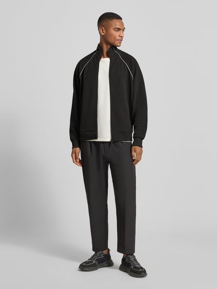 Männermodel trägt Regular Fit Sweatjacke aus Baumwoll-Mix von BOSS Green, Schwarz mit Kontraststreifen, Ganzkörperansicht von vorne.