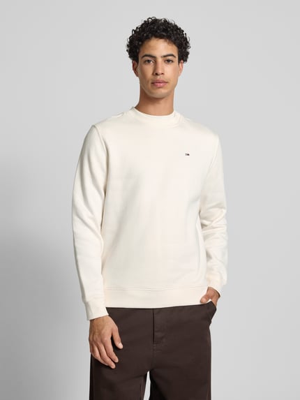 Männermodel trägt Regular Fit Sweatshirt aus Baumwoll-Mix von Tommy Jeans, Optik: Unifarben, Logo-Stitching, Ganzkörperansicht von vorne.