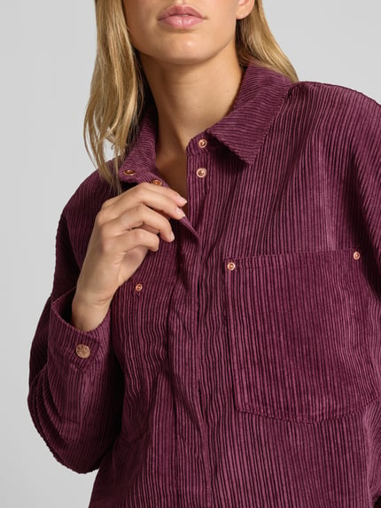 Frauenmodel trägt Oversized Hemdjacke mit verdecktem Druckknopfverschluss Modell 'JANINE-RAI' von ONLY in dunkelviolett, Ripp-Textur, Nahaufnahme Oberkörper, Damen Hemdjacke von ONLY.