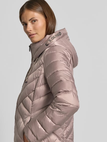Vrouwenmodel draagt glanzend rosékleurig gewatteerd jack met capuchon, Slim Fit Steppjacke mit Zweiwege-Reißverschluss van s.Oliver RED LABEL, zijaanzicht dichtbij