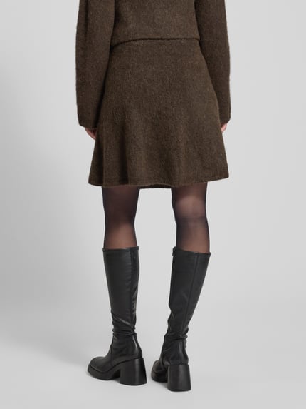 Frauenmodel trägt Mini-Rock aus Woll-Mix mit Alpaka Modell 'LULU' von Selected Femme, Optik: Unifarben, Passform: Ausgestellt, gebürstete Strick-Textur, Mini-Länge, Bundabschluss: Elastisch, Materialverarbeitung: Strick, Ganzkörperansicht Rückansicht.