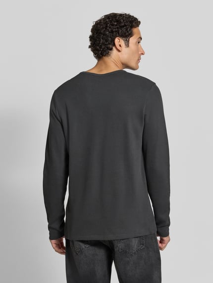 Männermodel trägt Regular Fit Longsleeve aus reiner Baumwolle Modell 'Basic' von Lindbergh in Dunkelgrau, Ganzkörperansicht Rückansicht. Rückenlänge bei Größe M: 73 cm, Rundhalsausschnitt, klare Struktur.