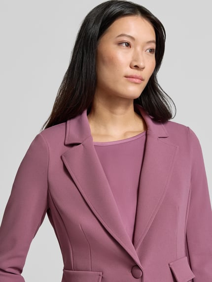 Vrouwenmodel draagt Blazer met Reverskraag van Rinascimento in mauve, elastische materiaalmix, getailleerde pasvorm, klepzakken, knoopsluiting, ruglengte bij maat S 63 cm, Nahaufnahme Oberkörper