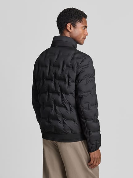 Męski model nosi Regular Fit Bomberjacke mit reflektierenden Details od Tom Tailor, czarna pikowana tekstura, bluzon, Ganzkörperansicht Rückansicht, Herren Bomberjacke / bluzon od Tom Tailor