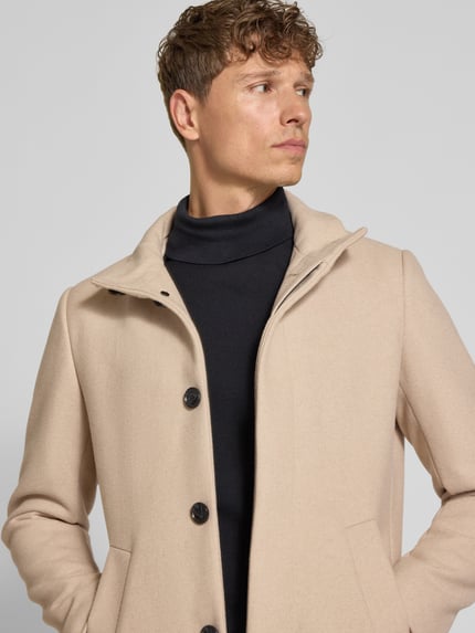 Männermodel trägt Regular Fit Mantel aus Baumwoll-Mix mit Viskose-Anteil von Matinique, Stehkragen, beige, Nahaufnahme Oberkörper.