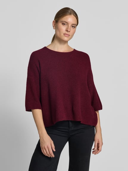Frauenmodel trägt Oversized Strickpullover mit Leinen-Anteil von American Vintage in Dunkelrot, grobe Struktur, Halbarm, Ganzkörperansicht von vorne.