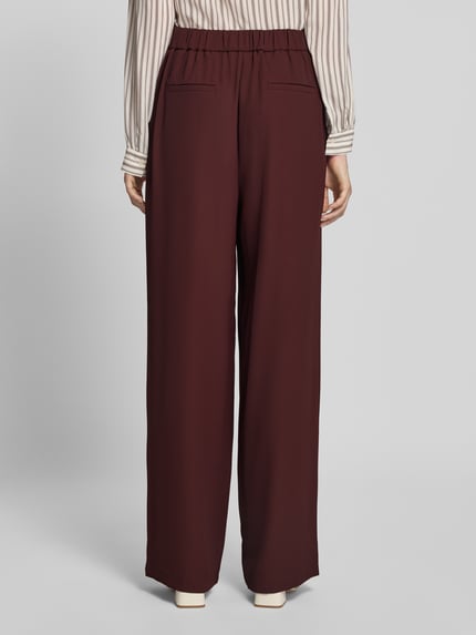 Kobieta nosi Wide Fit Hose mit Gesäßtaschen von Jake*s Collection, elastyczna mieszanka materiałów, kieszenie z tyłu, częściowo elastyczny pas, całość z tyłu