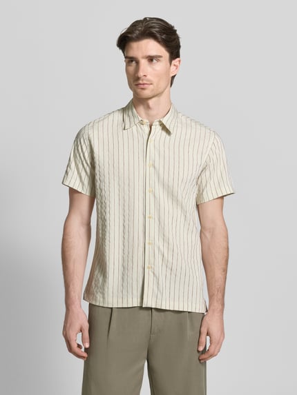 Männermodel trägt Regular Fit Freizeithemd mit Viskose-Anteil Modell 'REDFORD' von Guess, Kentkragen, creme mit Streifen, Ganzkörperansicht von vorne.