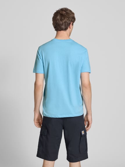 Männermodel trägt T-Shirt mit Label-Print und Rundhalsausschnitt von CHAMPION in Hellblau, Baumwolle, Regular Fit, Rückenansicht, Ganzkörperansicht Rückansicht