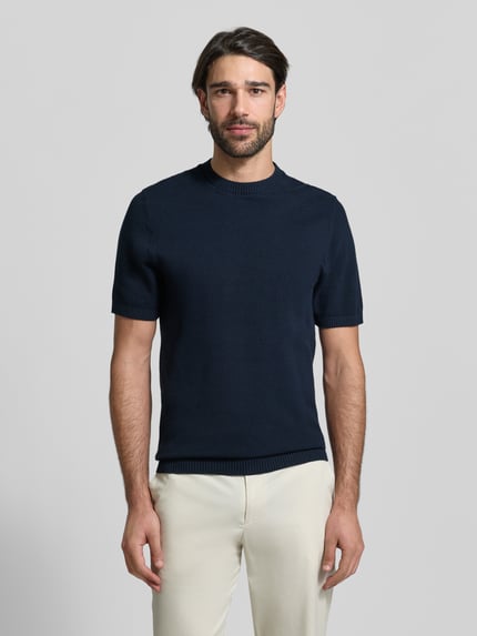 Männermodel trägt Regular Fit T-Shirt aus reiner Baumwolle von MCNEAL, dunkelblau, Strukturmuster, gerippter Stehkragen, Ganzkörperansicht von vorne.