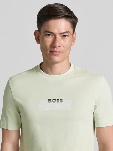 Männermodel trägt Regular Fit T-Shirt aus reiner Baumwolle Modell 'Te_LOGOTAPE' von BOSS Orange in Optik: Unifarben, Nahaufnahme Oberkörper.