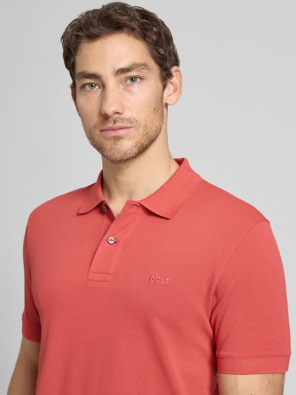 Männermodel trägt Regular Fit Poloshirt aus reiner Baumwolle Modell 'PALLAS' von BOSS, Optik: Unifarben, Nahaufnahme Oberkörper.