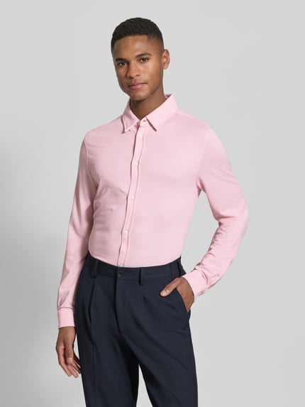 Męski model nosi Koszulę casualową Slim Fit Freizeithemd mit Kentkragen model 'Roni' od CINQUE, mieszanka bawełny, różowy kolor, długa listwa guzikowa, z długim rękawem, długość tyłu w rozmiarze M: 74 cm, szerokość ramion w rozmiarze M: 46 cm, długość rękawów w rozmiarze M: 69 cm, widok całej sylwetki od przodu.