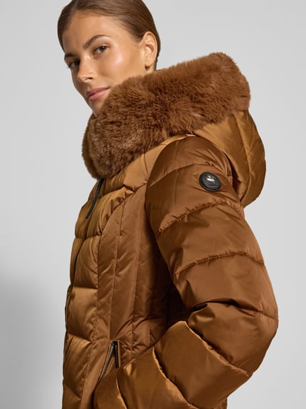 Frauenmodel trägt Steppjacke mit Kunstfell und Reißverschluss Modell 'DANIDA' von khujo in Braun, Nahaufnahme Oberkörper, Slim Fit, glänzende Oberfläche, Reißverschlusstaschen, KI-modifiziertes Bild.