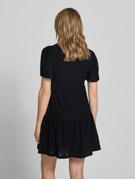 Frauenmodel trägt Mini-Freizeitkleid mit Lochstickmuster Modell 'SMILLA LIFE' von Only in Schwarz, unifarben, Regular Fit, Rückansicht.