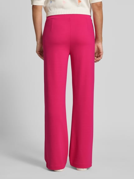 Frauenmodel trägt Flared Cut Hose mit elastischem Bund von Smith and Soul aus pinkem Material-Mix mit Viskose-Anteil, Ganzkörperansicht Rückansicht.