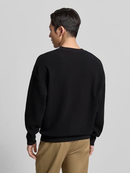 Męski model nosi Regular Fit Sweatshirt aus reiner Baumwolle Modell 'DAFFLYN' od HUGO, czarny, struktura jacquard, widok całej sylwetki od tyłu.