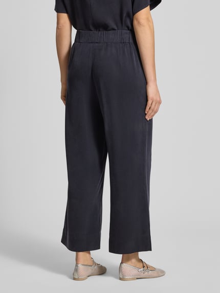 Frauenmodel trägt Weite Hose aus Lyocell von Marc O'Polo Denim, Optik: Unifarben, Regular-Fit, Material Lyocell, Ganzkörperansicht Rückansicht.