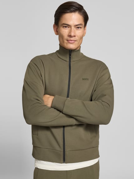 Männermodel trägt olivefarbene Regular Fit Sweatjacke aus Baumwoll-Mix Modell 'SW_Union Skaz' von BOSS, Nahaufnahme Oberkörper, Herren Sweatjacke von BOSS.