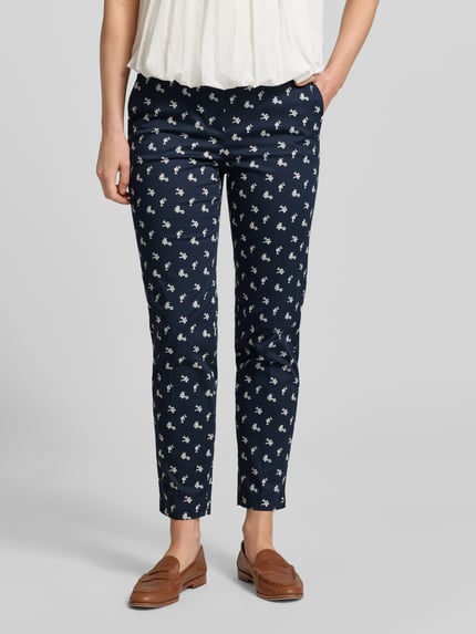 Vrouwenmodel draagt Hose im Allover-Look met riem van Christian Berg Woman, katoen- en viscosemix, slim fit, verkorte pasvorm, all-over look, donkerblauw met wit motief, bandwijdte maat 36: 40 cm, binnenbeenlengte maat 36: 70 cm, voorkant, close-up onderlichaam.