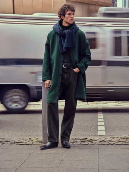 Männermodel trägt Baggy Fit Jeans im 5-Pocket-Design von Review aus Baumwoll-Viskose-Mix in dunklem Farbton, Ganzkörperansicht von vorne.