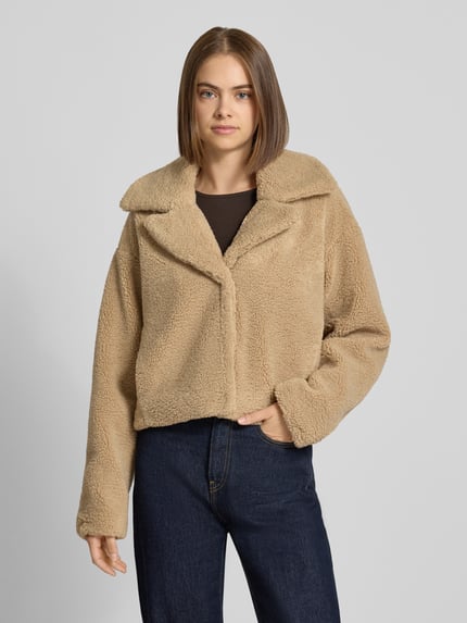Vrouwenmodel draagt Cropped Jacke aus Teddyfell Modell 'Nati' van NOISY MAY®, beige, cropped fit, reverskraag, rechte vormen, textuur als teddy, Ganzkörperansicht van voren.