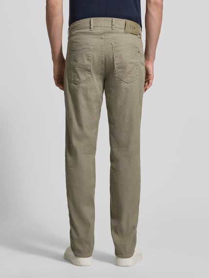 Männermodel trägt Regular Fit Stoffhose aus Baumwoll-Leinen-Mix Modell 'CADIZ' von Brax in Unifarben mit Label-Patch, 5-Pocket-Design, Ganzkörperansicht Rückansicht.