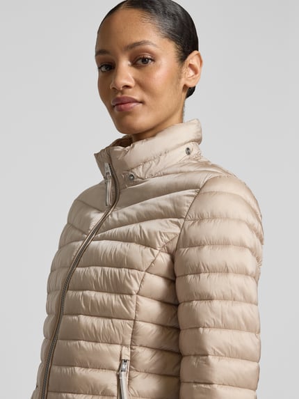 Frauenmodel trägt Steppjacke mit Zweiwege-Reißverschluss von Fuchs Schmitt in Beige, Regular Fit, Stehkragen, Nahaufnahme Oberkörper.