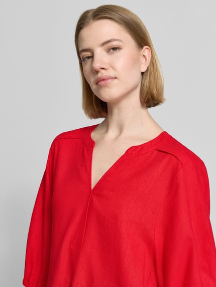 Frauenmodel trägt Bluse aus Leinen-Mix mit verlängertem Rücken Modell 'Lava' von FREE/QUENT in Rot, lockerer Schnitt, Nahaufnahme Oberkörper.