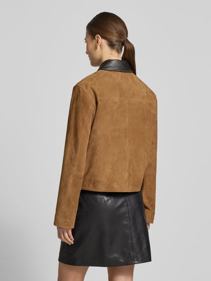 Modelka nosi Veloursjacke mit Lederkontrastkragen od Jake*s Casual, welur, krój regular fit, kołnierzyk w kontrastowym kolorze, kieszenie z patką, widok sylwetki od tyłu.