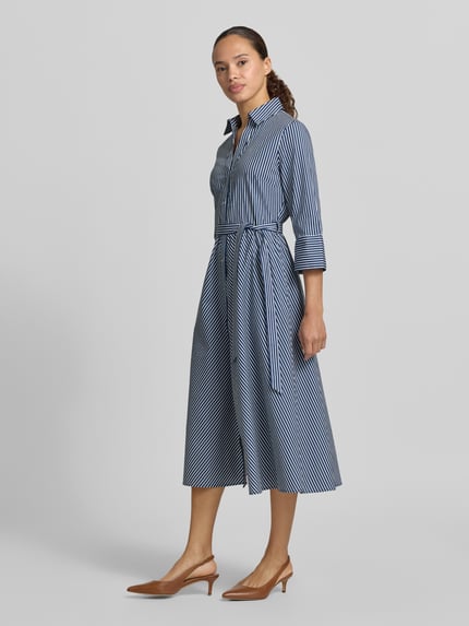 Frauenmodel trägt Hemdblusenkleid mit Bindegürtel und Knopfleiste von Zero, blau-weiß gestreift, taillierter Schnitt, Ganzkörperansicht von vorne.
