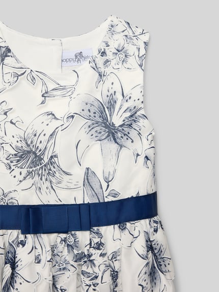 Mädchen trägt Regular Fit Kleid mit floralem Allover-Print von Happy Girls, Baumwoll-Mix, Zierschleife, Nahaufnahme Oberkörper.