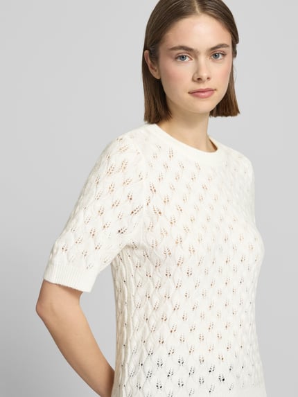 Vrouwenmodel draagt Regular Fit Pullover met Woll-Anteil model 'LELOU' van Pieces, look: effen, materiaalverwerking: knitwear, korte mouw, ronde hals, geribde mouw- en rompzoom, detailopname bovenlichaam.