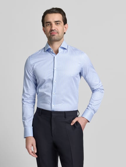Mannenmodel draagt Slim Fit Businesshemd uit puur katoen model 'HANK' van BOSS met blauwe strepen, haifischkraag, eenrijige knoopsluiting, lange mouw, sportmanchet, afgeronde zoom, label stitching detail, rugpas, voorkant hele lichaam.
