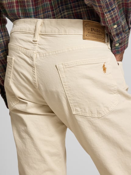 Männermodel trägt Slim Fit Jeans met 5-pocketmodel van Polo Ralph Lauren in lichte kleur, mix van katoen en elastaan, detailopname rugaanzicht. Bandwijdte maat 32/34: 42 cm, binnenbeenlengte: 85 cm.