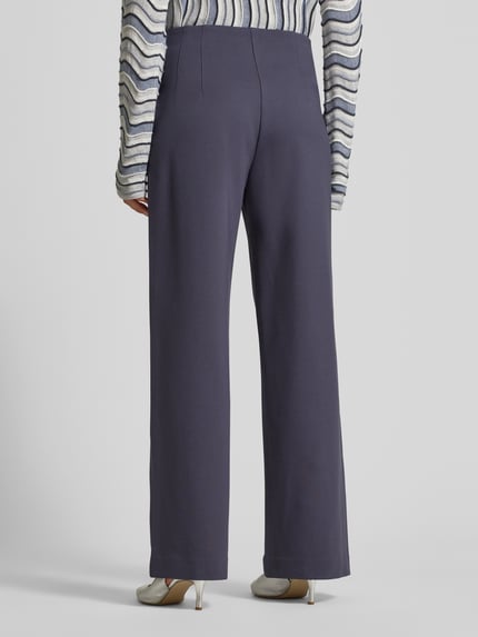 Frauenmodel trägt Weite Hose aus Viskose-Mix von s.Oliver BLACK LABEL in Optik: Unifarben, Passform: Wide Leg, Ganzkörperansicht Rückansicht.