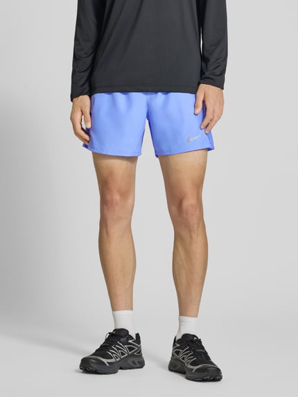 Männermodel trägt Shorts mit seitlichen Eingrifftaschen und Logo-Print von NIKE TRAINING, hellblau, Loose Fit, Ganzkörperansicht von vorne.