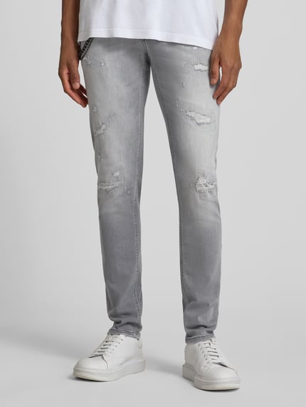 Männermodel trägt Tapered Fit Jeans mit Ketten-Detail von Antony Morato, grauer Baumwoll-Elasthan-Mix im Destroyed-Look, 5-Pocket-Design, Ganzkörperansicht von vorne.