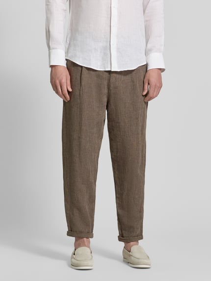 Männermodel trägt Relaxed Fit Stoffhose aus Leinen-Baumwoll-Mix Modell 'RON' von SELECTED HOMME mit Melange-Optik, Nahaufnahme Unterkörper.