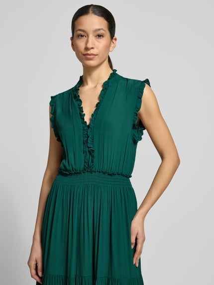 Frauenmodel trägt Maxikleid aus Viskose mit V-Ausschnitt und Rüschen von Apricot in sattem Grün, A-Linie, Stufen-Look, Nahaufnahme Oberkörper. Rückenlänge bei Größe S: 139 cm, Brustweite bei Größe S: 34 cm.